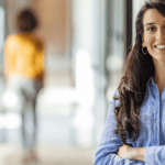 Women smiling in an office hallway.