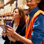 Warehouse worker looking at ipad checking inventory.